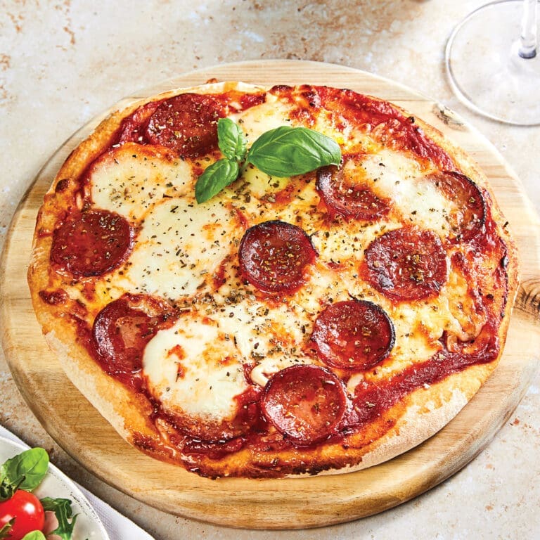 Jurassic classic pizza on a table, with lot's of toppings.